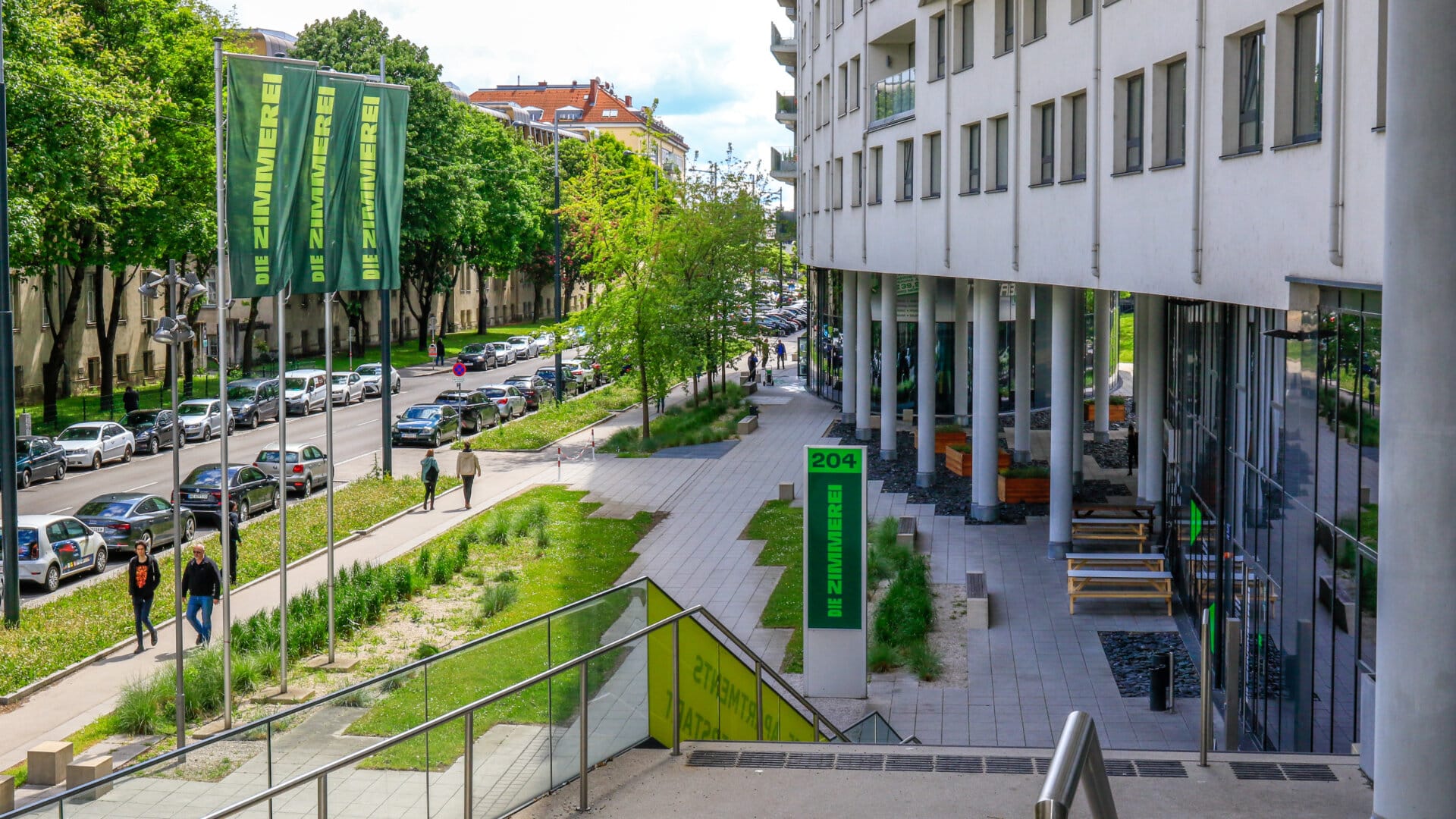 Blick auf die Vorgartenstraße 204 in Wien mit modernem Wohngebäude, Grünflächen und Fußweg entlang der Straße
