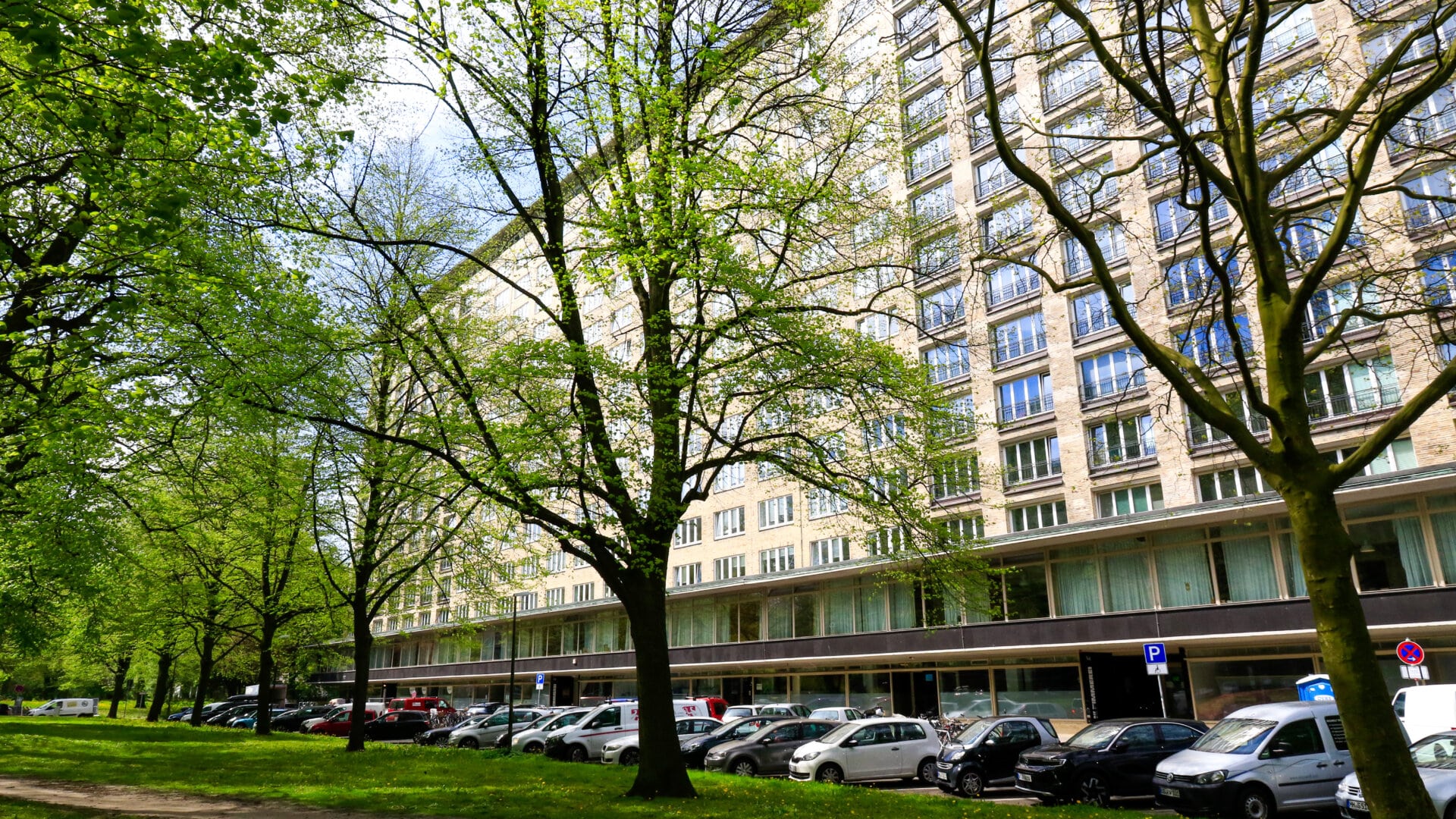 Mehrstöckiges Wohngebäude an der Oberstraße 46 in Hamburg-Grindel mit parkenden Autos und Bäumen im Vordergrund