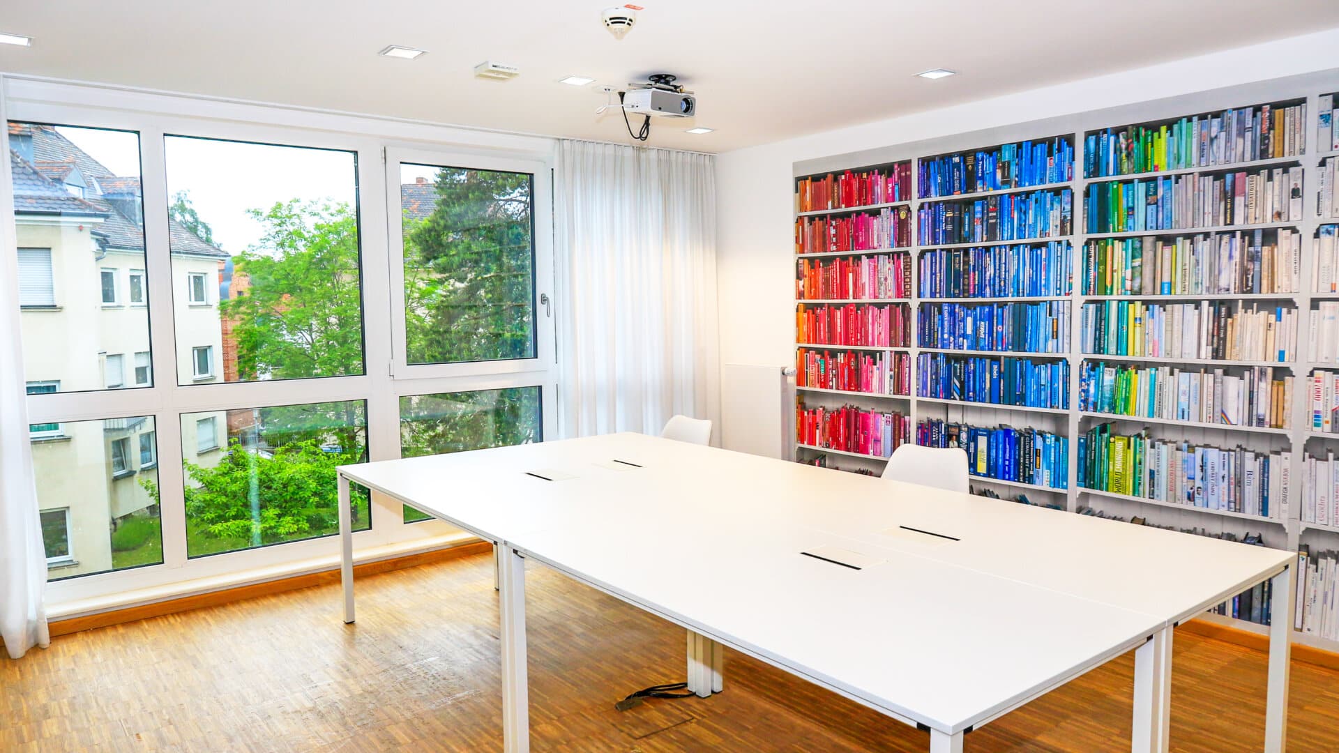 Besprechungsraum mit Tisch und Bücherregal